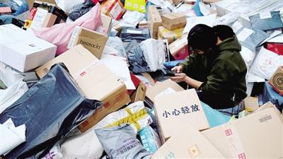 鄭州大學(xué)的快遞取件點，工作人員正在對卸了一地的快遞進行掃碼入庫。