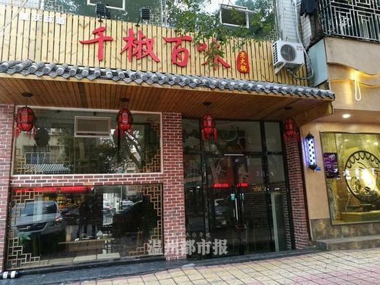 千椒百味位于安陽街道安康路，這家店關(guān)停顯得很匆忙，通過玻璃窗可以看到，桌椅擺放凌亂，一些用過的紙巾、碗筷散落桌上，后廚還有一塑料筐用過的碗碟尚未清洗。